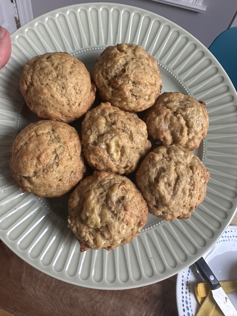 Seven banana muffins arranged on a green plate